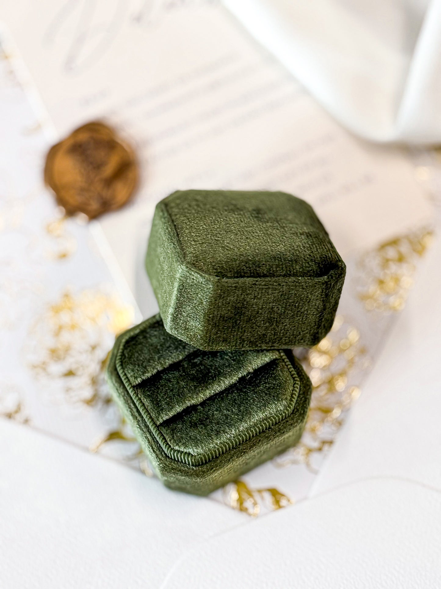 Green velvet jewelry box on a decorative surface w