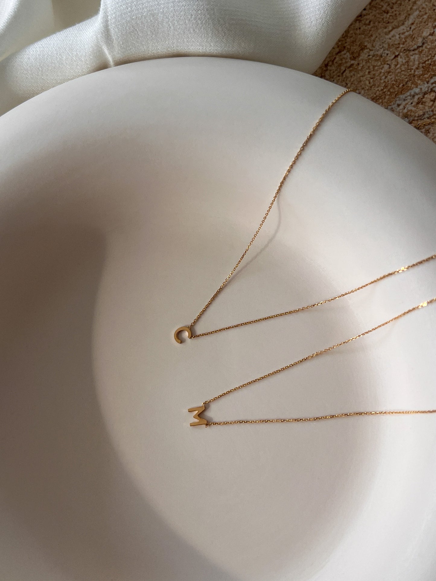 Delicate initial necklaces styled for everyday wear in yellow and rose gold