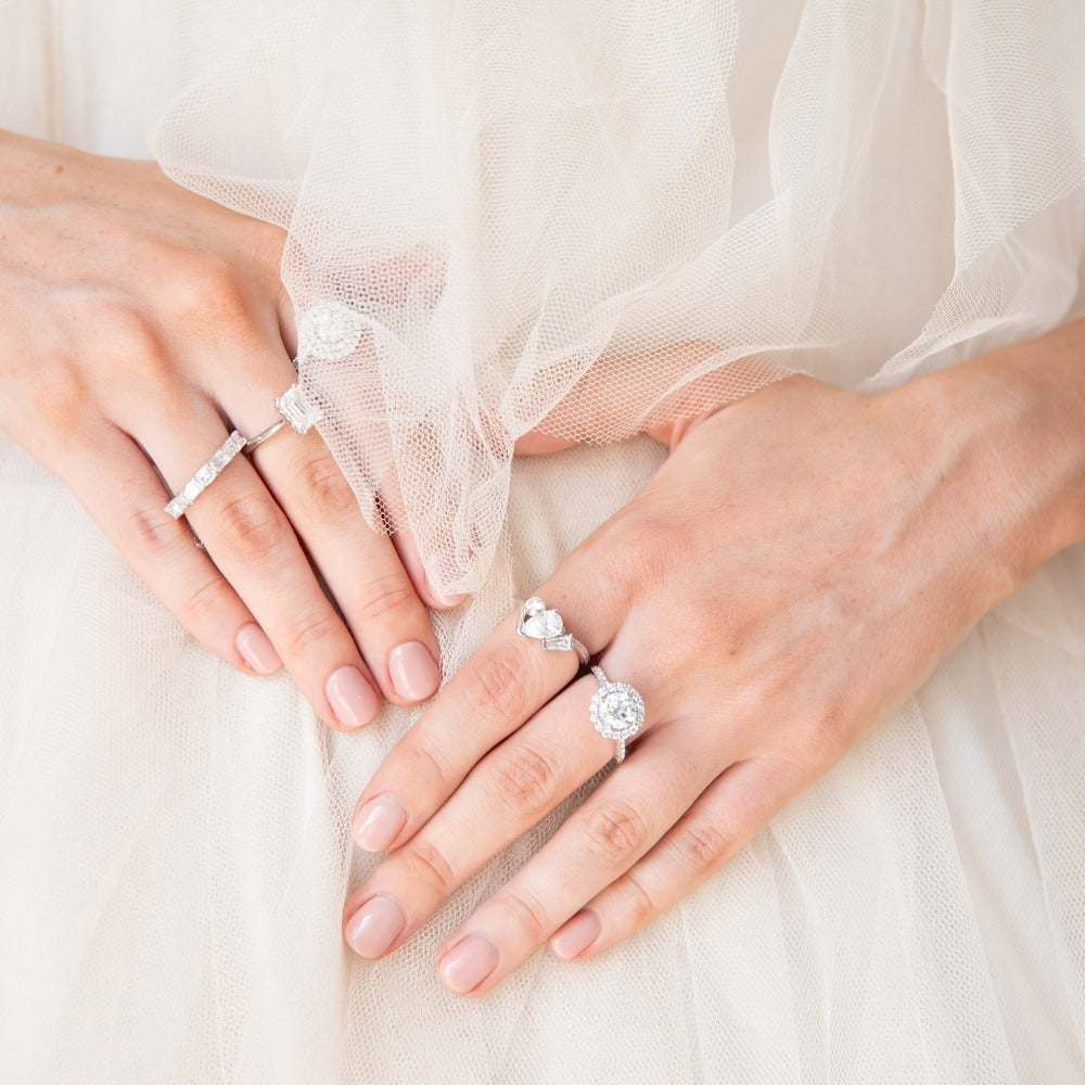 diamond rings engagement on 2 hands with tule backdrop