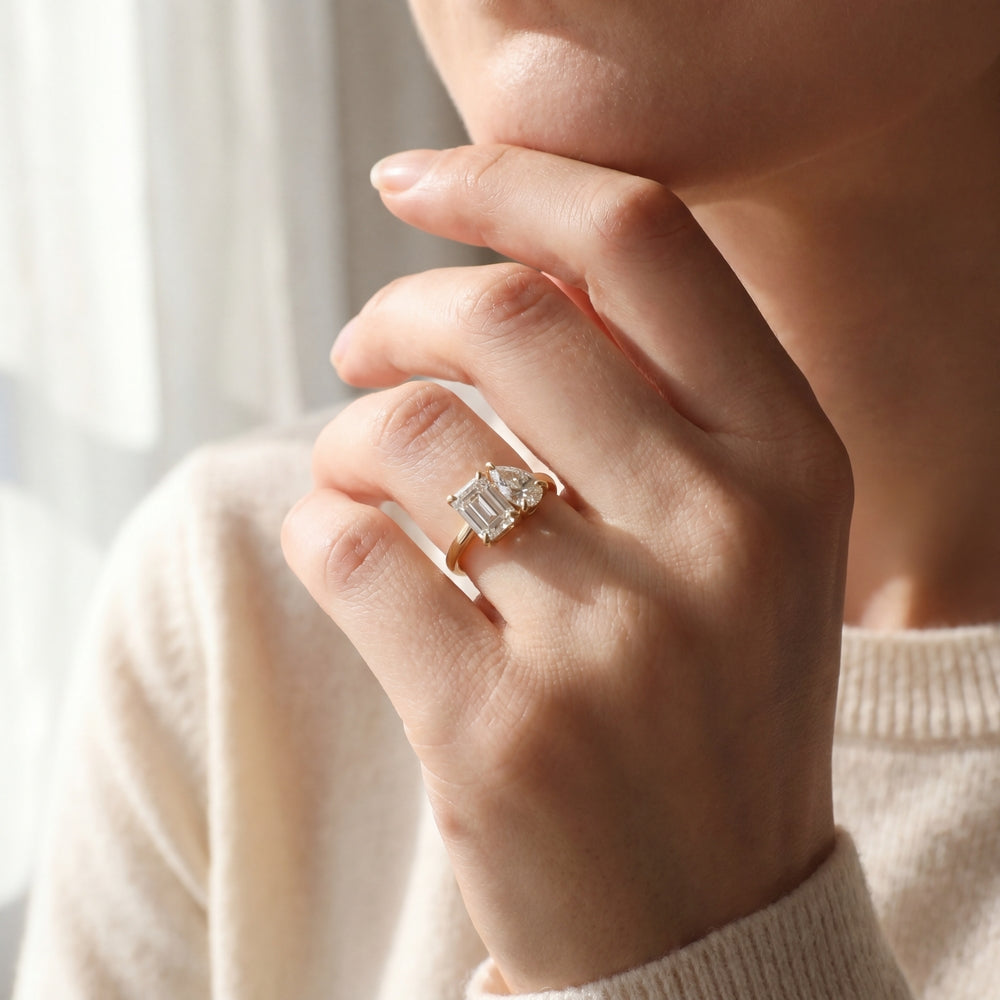 Close-up of a hand wearing a diamond ring with a blurred background