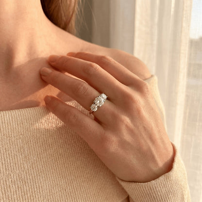 Hand wearing a diamond ring with a soft background