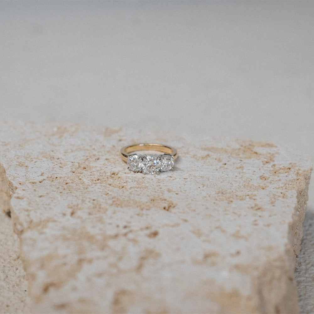 Gold ring with diamonds on a textured stone surface