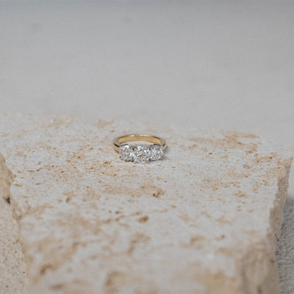 Gold ring with diamonds on a textured stone surface